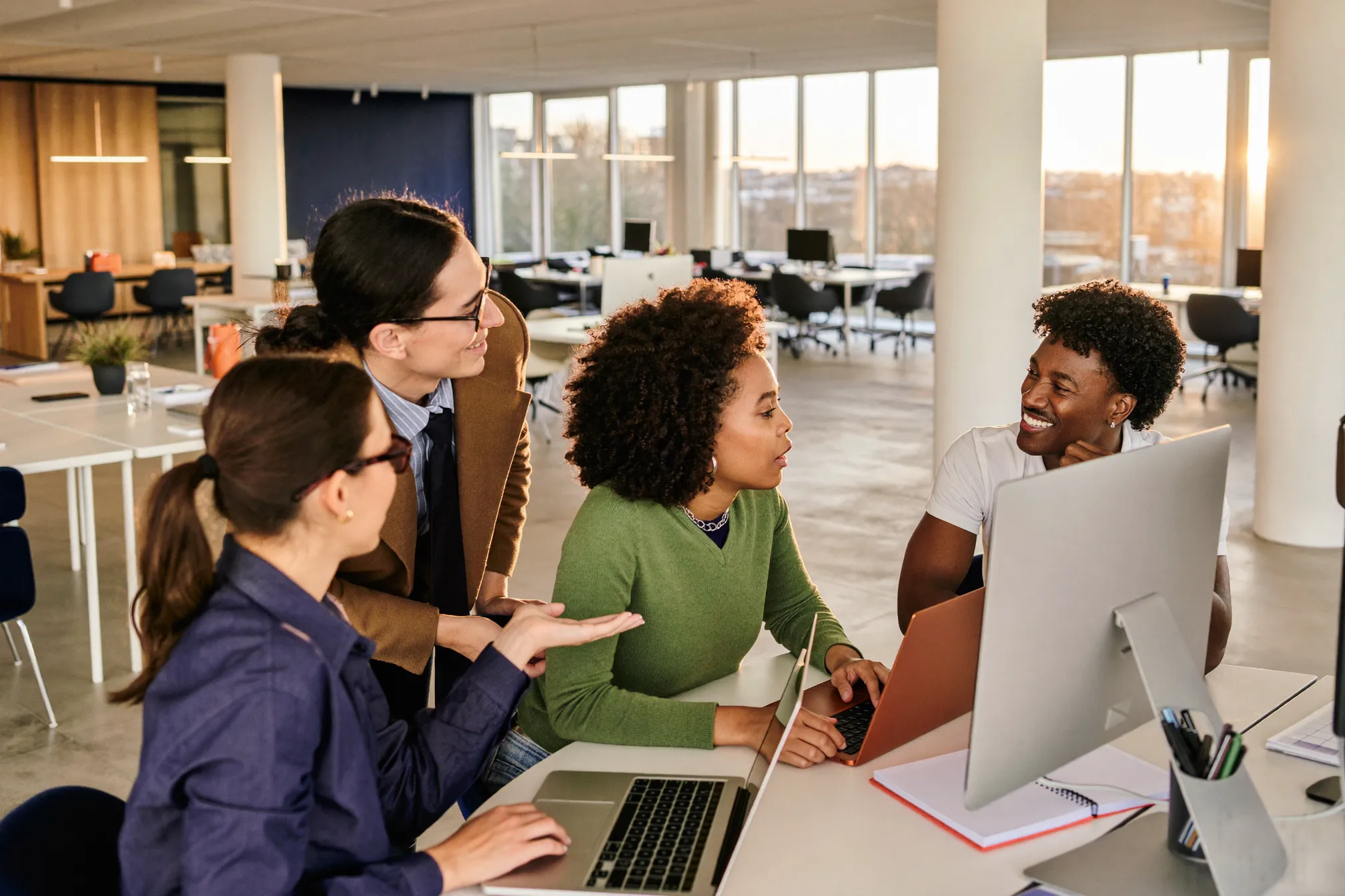 A team collaborating around a table in a bright, modern office lounge